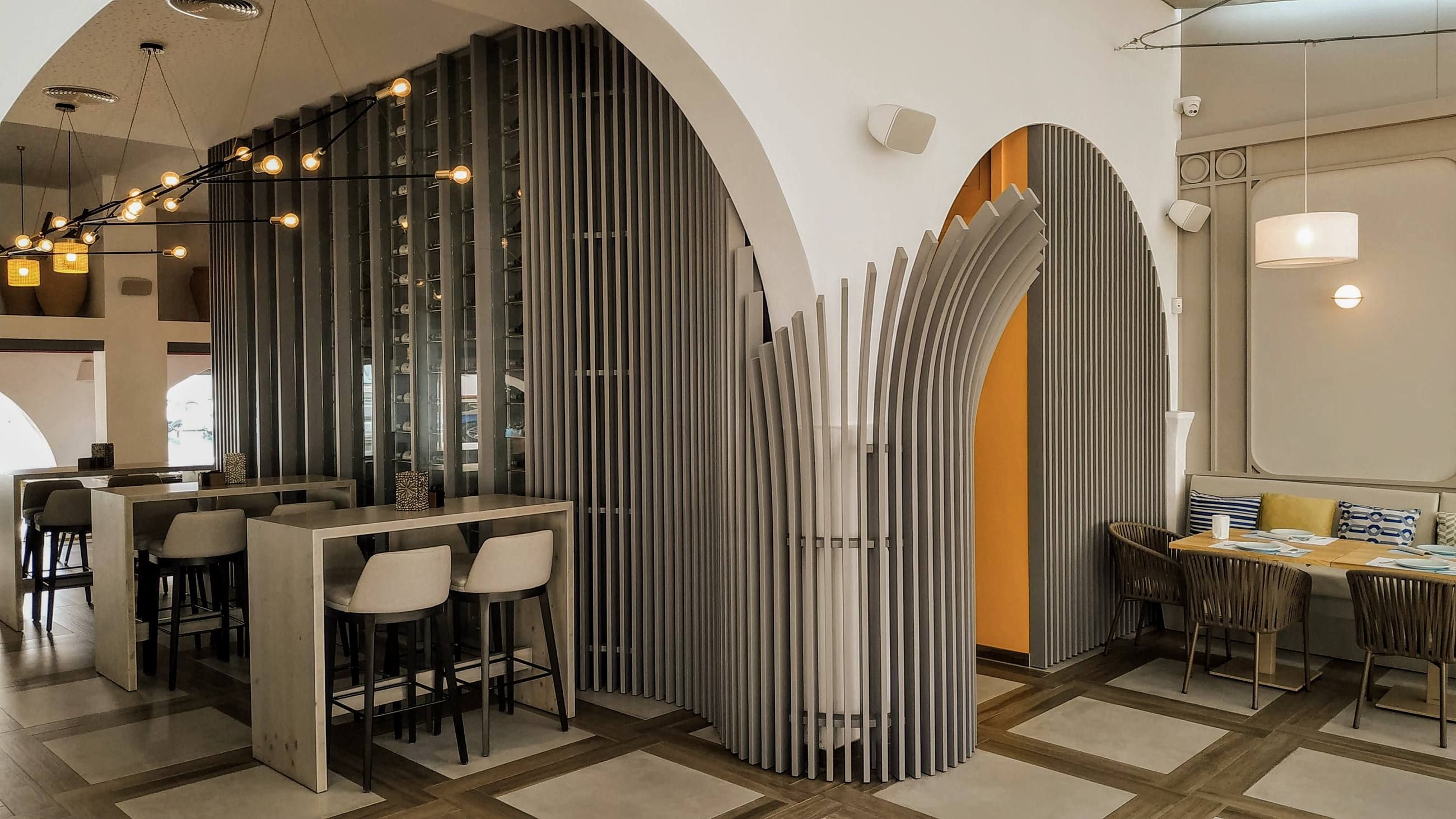 Interior de un local de hostelería con arcos y columnas curvas de listones de madera